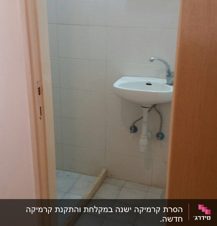 כיור מותקן בחדר אמבטיה עם אריחים לבנים